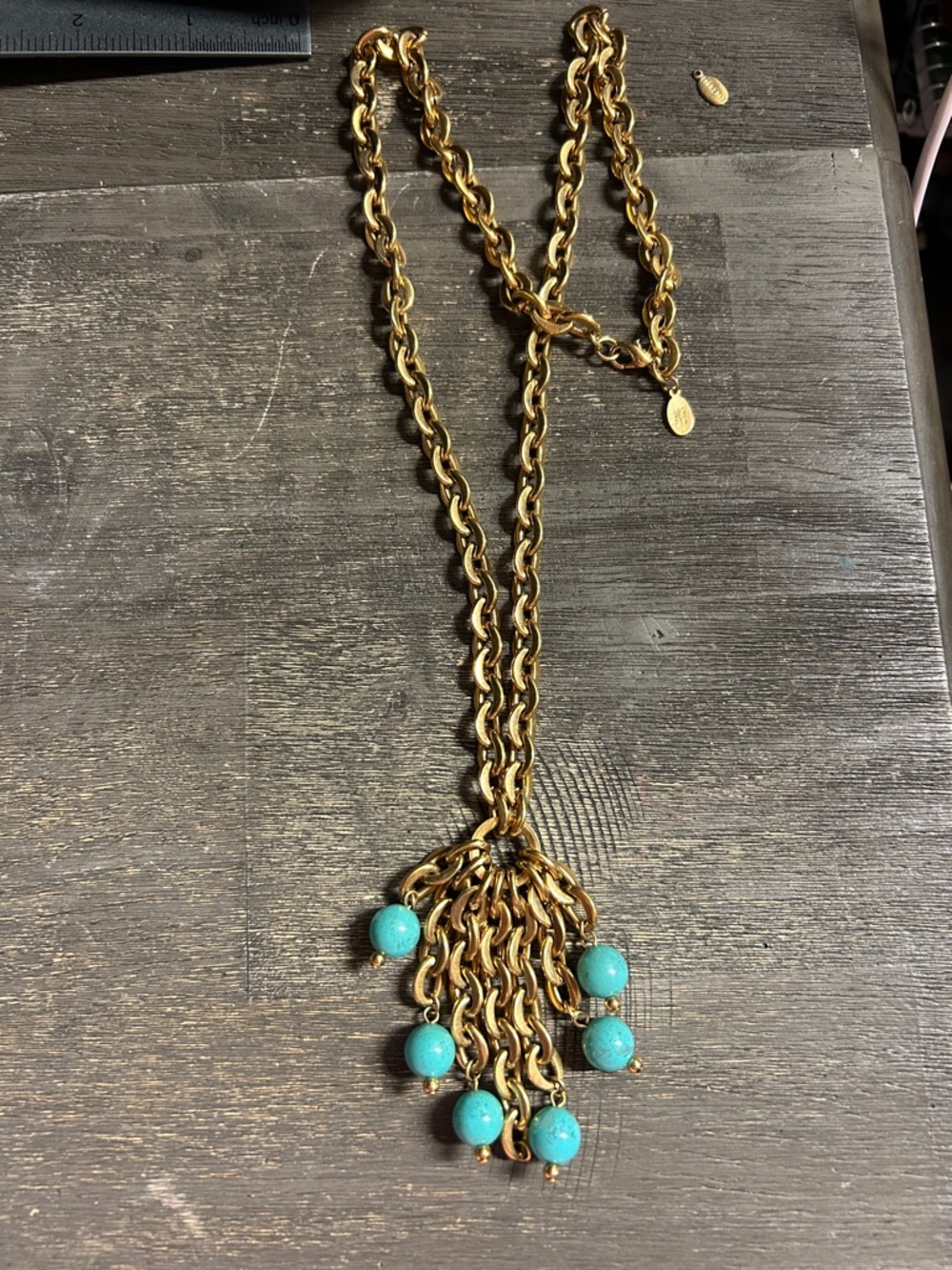 vintage Nolan Miller piece featuring a gold-tone chain and turquoise-blue beads